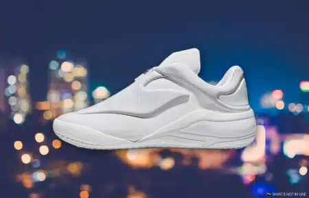 White athletic sneaker against a blurred city-light background
