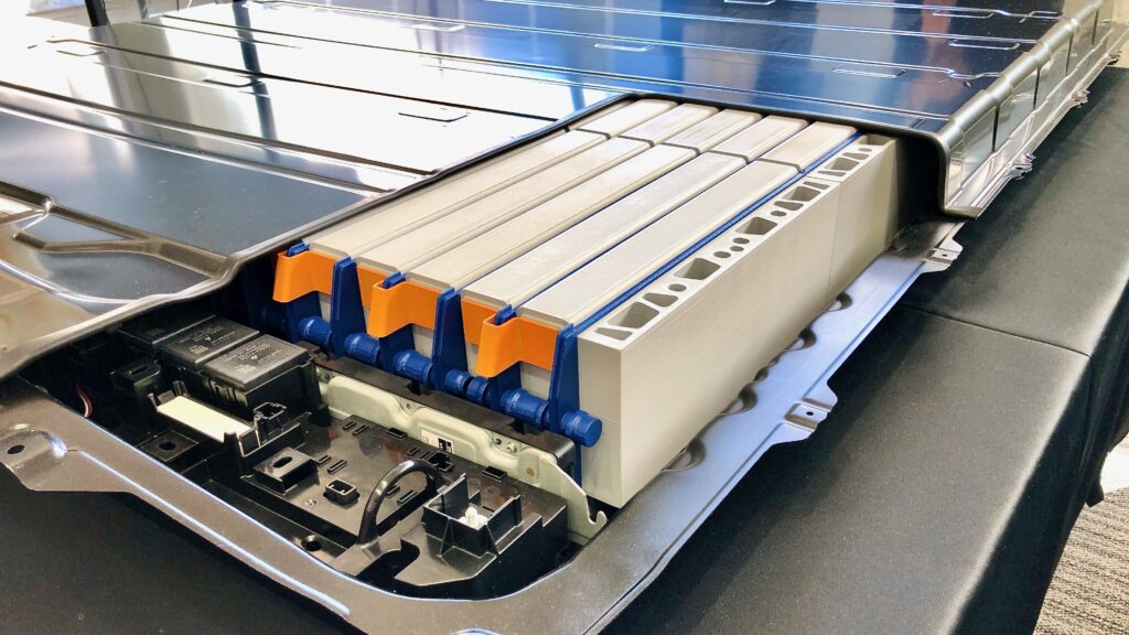 Exposed electric vehicle battery pack with multiple cell modules and blue-and-orange structural supports