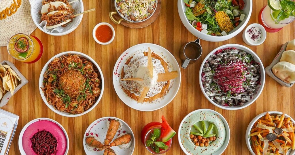 Yas Mall Restaurants: Where to Eat on Yas Island, Abu Dhabi Overhead view of assorted colorful Middle Eastern dishes and drinks arranged on a wooden table