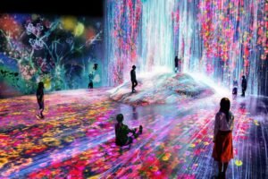 Immersive digital art installation with colorful projected flowers and cascading light around visitors