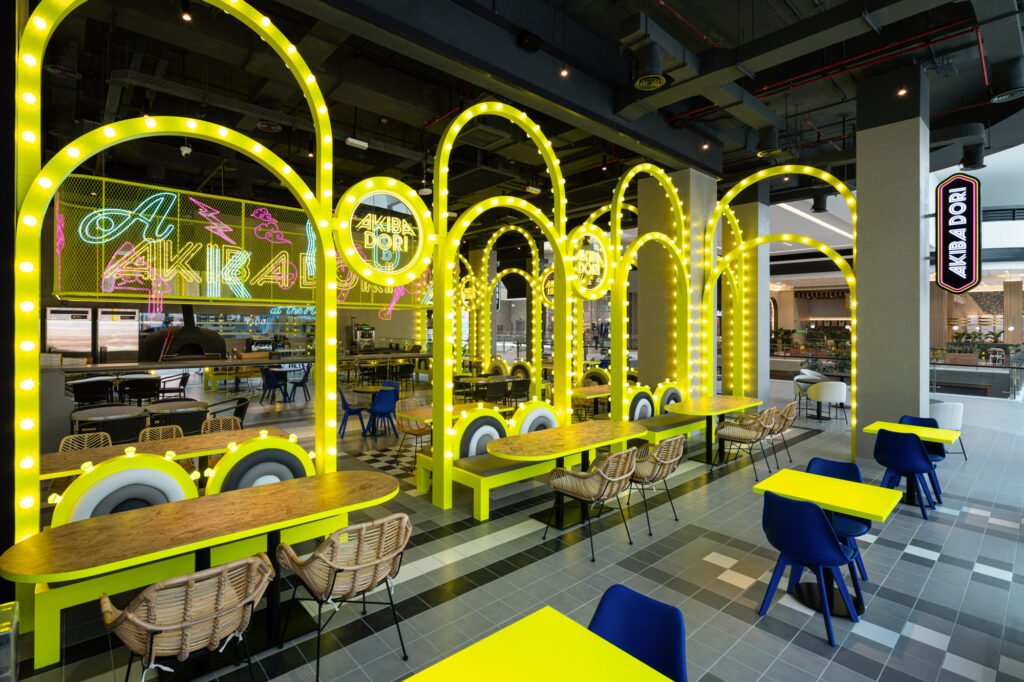 Food court at Dubai Hills Mall, with Akibadori signage and neon arch frames