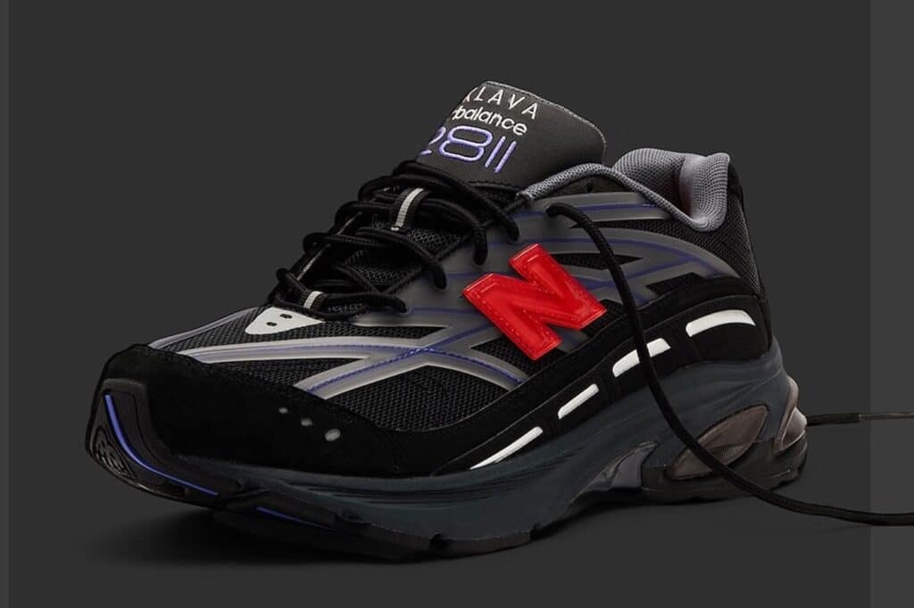 Black and grey New Balance 2811 sneaker with purple accents and a red logo