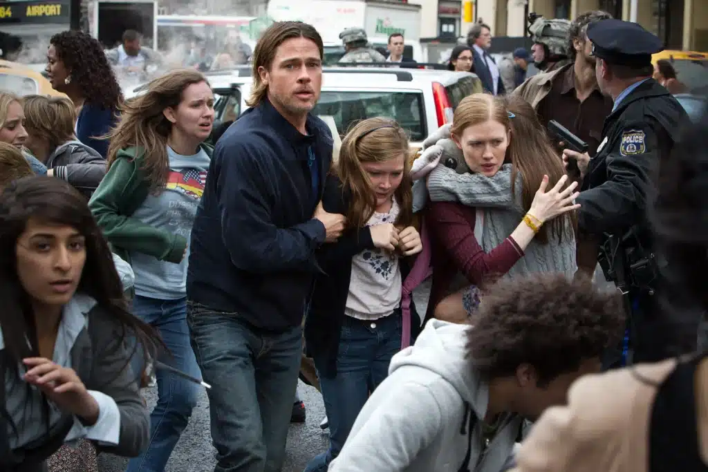 Crowded street scene with a man helping two distressed girls as police officers manage the surrounding crowd