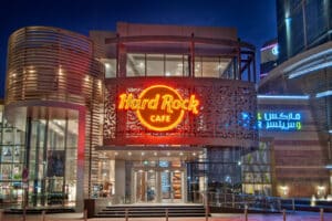 Hard Rock Cafe entrance glowing with neon signage at night, beside Arabic and English “Dubai Mall” signs