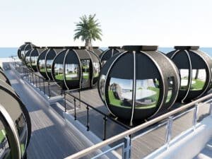 Futuristic spherical rooftop dining pods with glass windows, arranged along a deck overlooking the sea