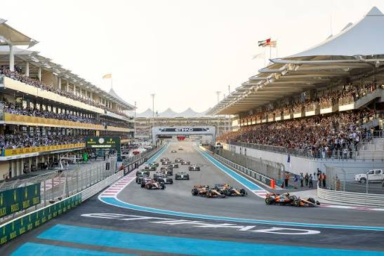 Abu Dhabi F1 cars race past packed grandstands on a brightly marked circuit