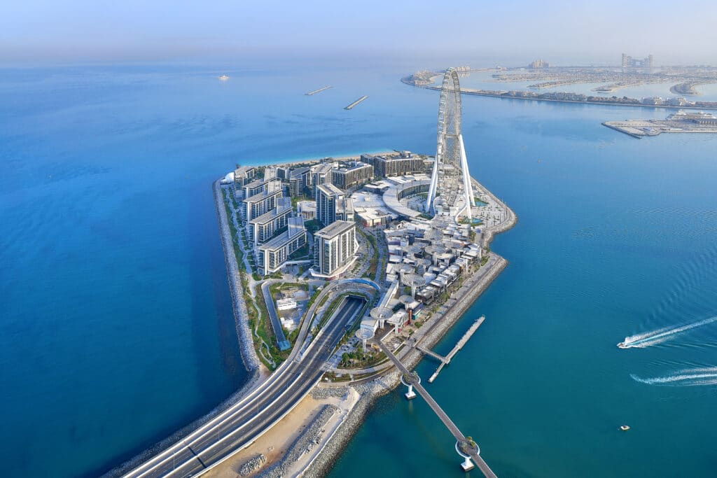Aerial view of Bluewaters Island with Ain Dubai, waterfront buildings, the road approach and pedestrian bridge.