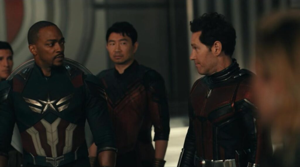 Three avengers doomsday trailer superheroes stand together indoors, with two looking toward each other