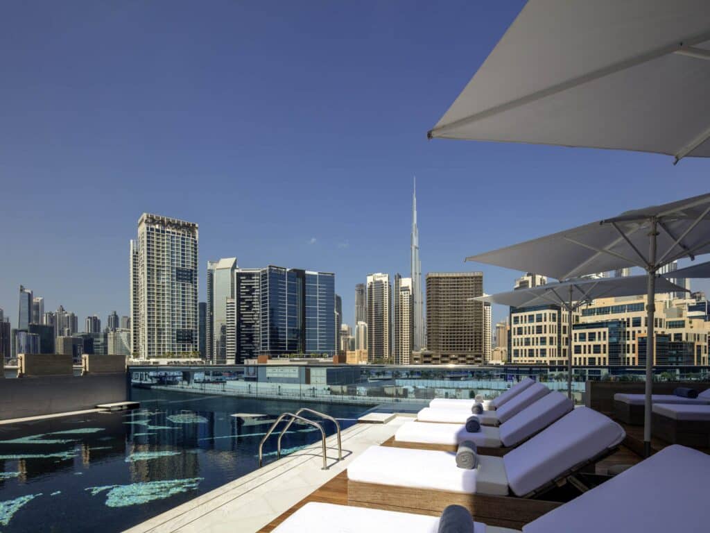 Hyde Hotel Dubai Rooftop pool with lounge chairs overlooking Dubai’s skyline and the Burj Khalifa